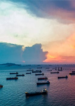 Oil ships on the water at dusk representing Lacima's work in the LNG markets, offering a complete solution for structuring and trading, to risk management of LNG portfolios.