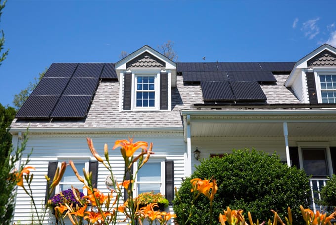 Image of a house with solar panels on the roof, representative of Lacima's product solutions for structuring and trading to risk management of renewable energy portfolios.