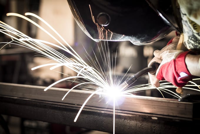 Stock image of welder symbolising Lacima's software offerings for metals & mining risk management, valuation, and analytics