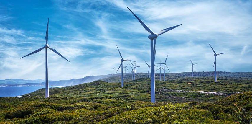 Wind farm at sunset representing renewable energy risk analytics and earnings-at-risk modelling for Australian generation portfolios